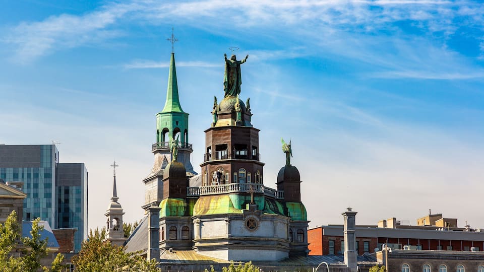 A historic church with a green spire and a statue on top.