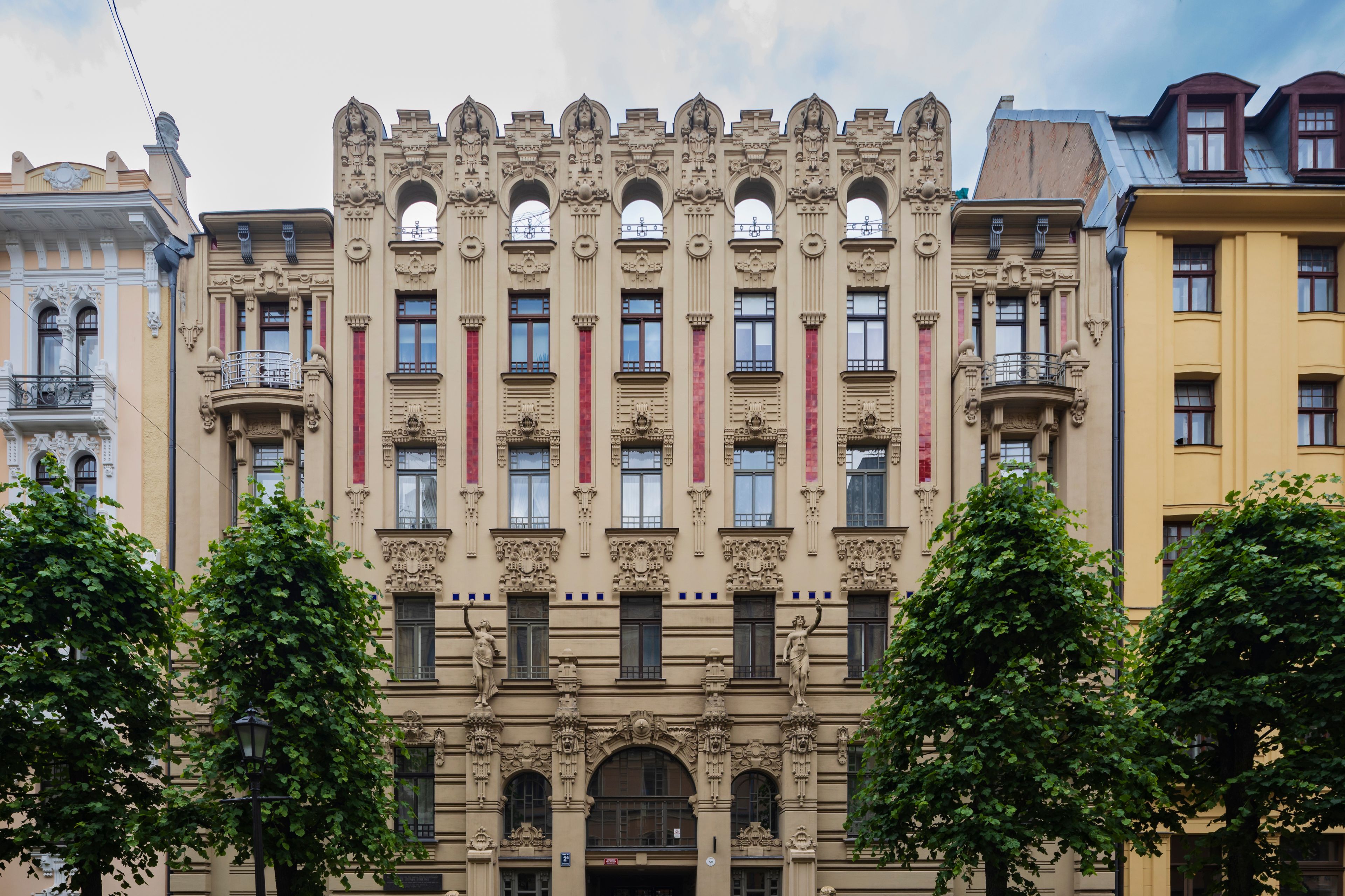 A historic building with ornate facades, large windows, and statues.