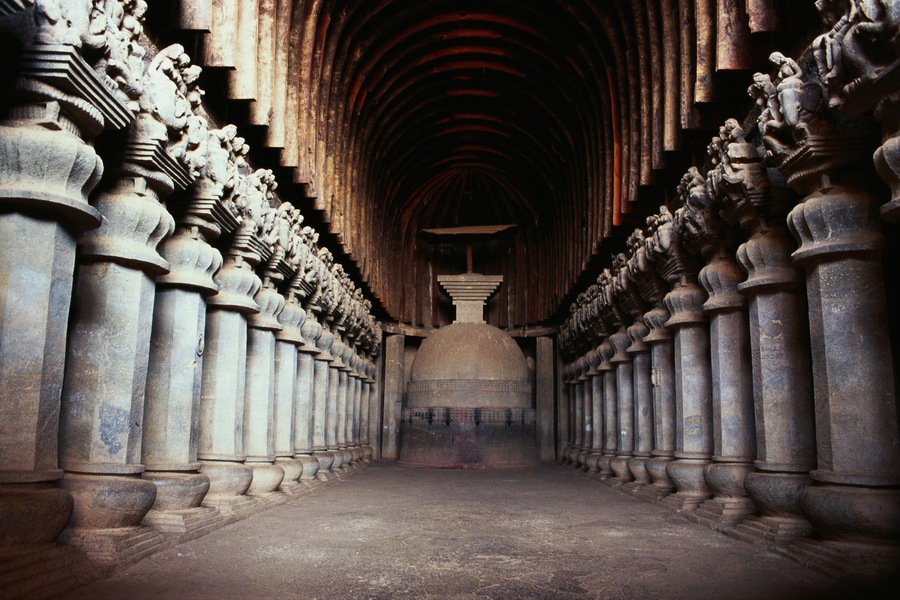 A corridor with ornate columns and statues.