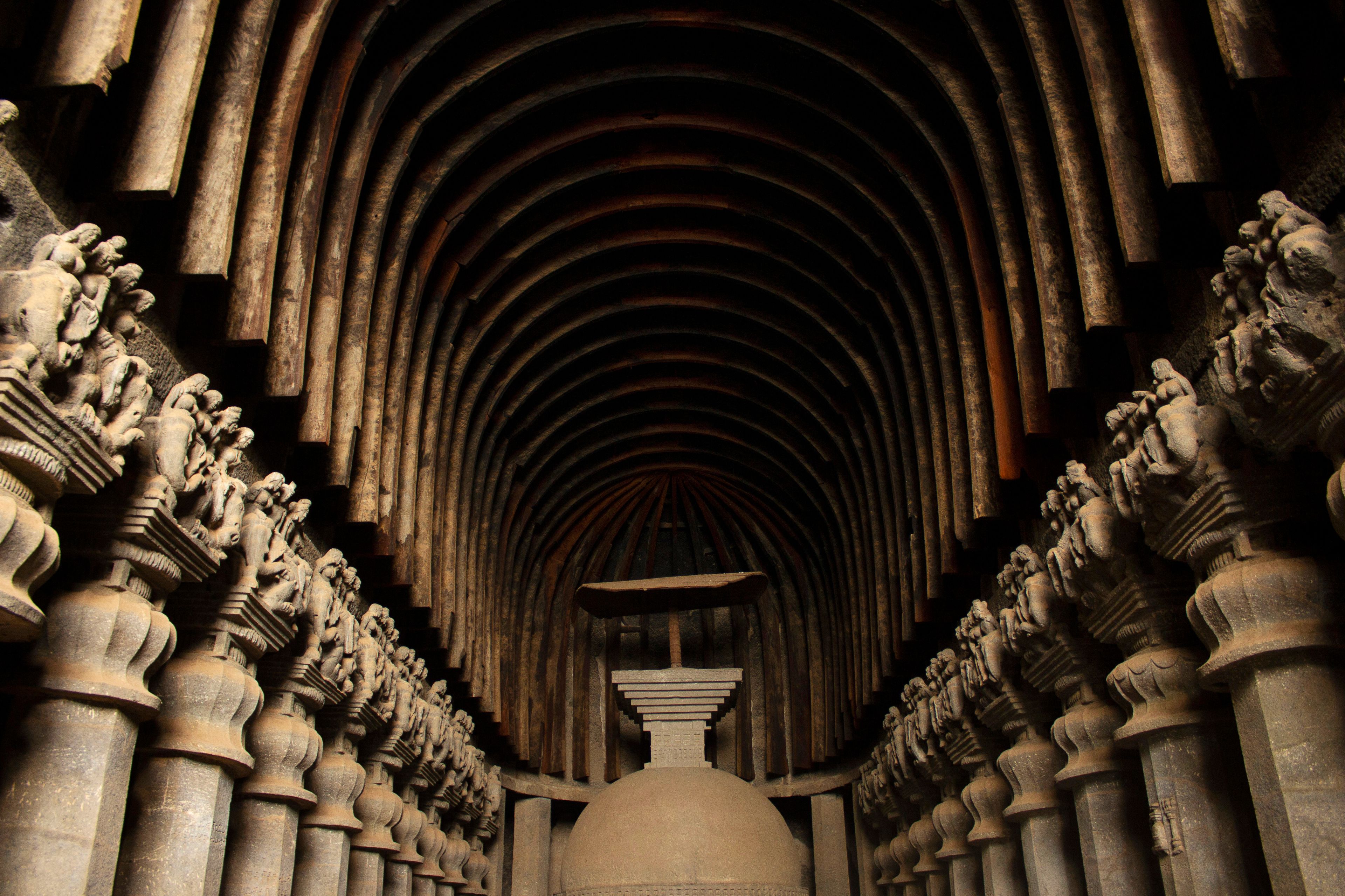 A long corridor with a series of statues on either side and a large dome at the end.