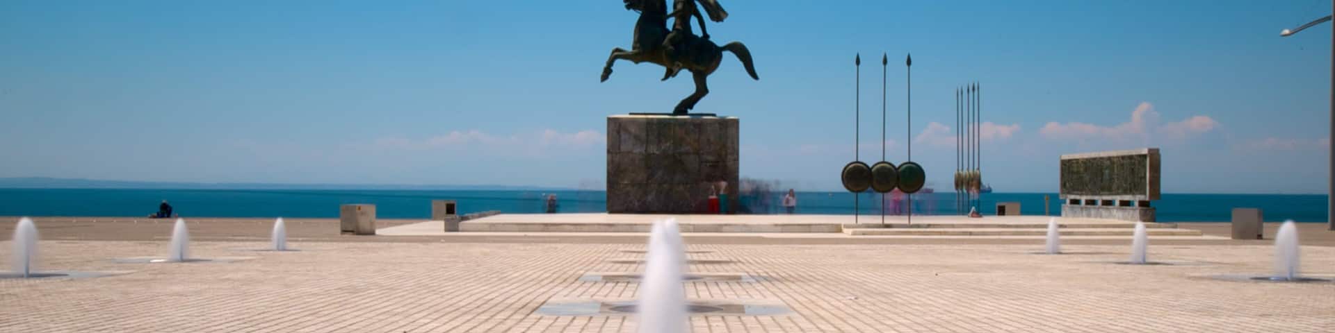A statue of a man on a horse, a fountain, and a clear blue sky.