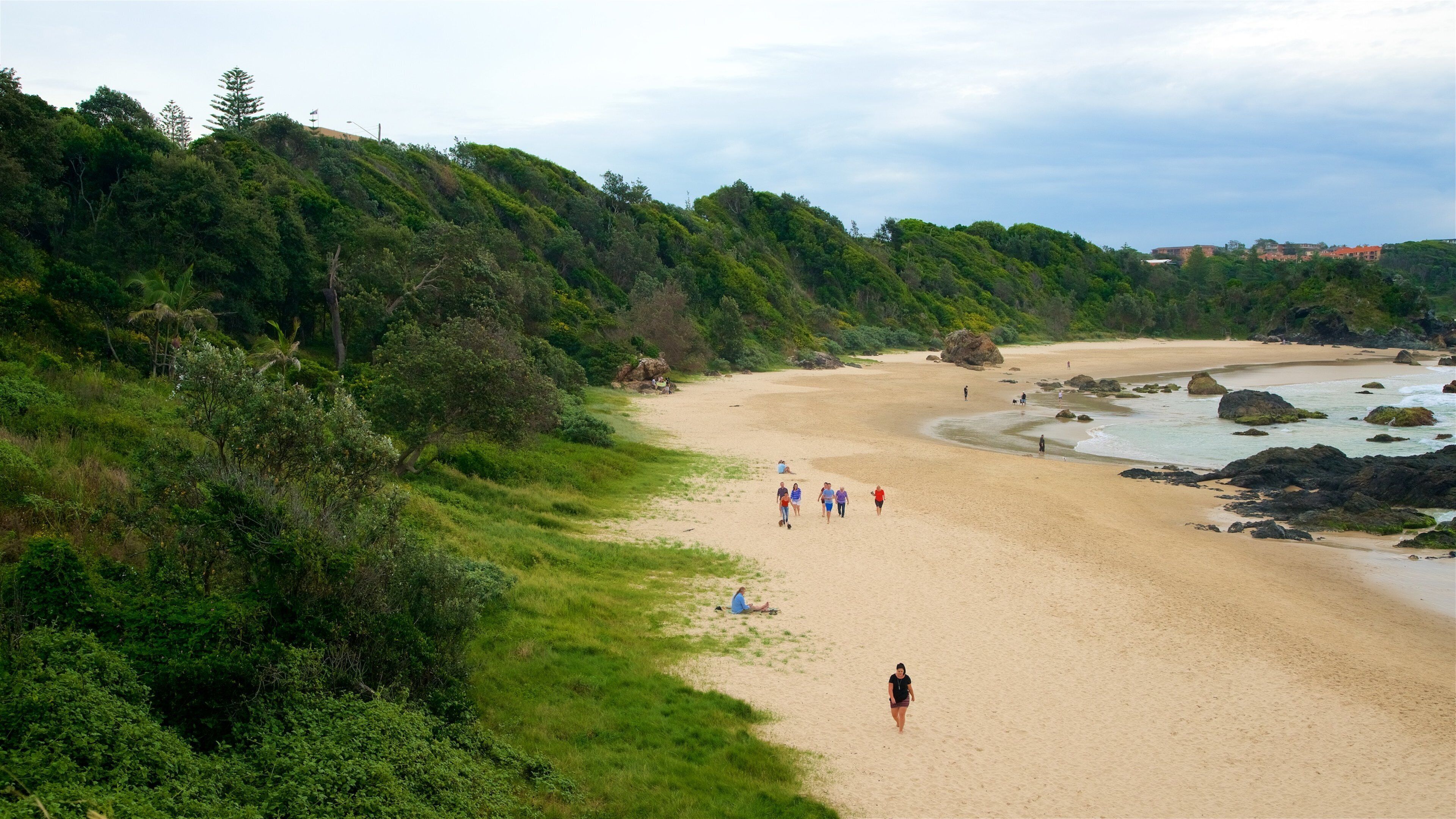 Port Macquarie que inclui uma praia e litoral rochoso assim como um pequeno grupo de pessoas