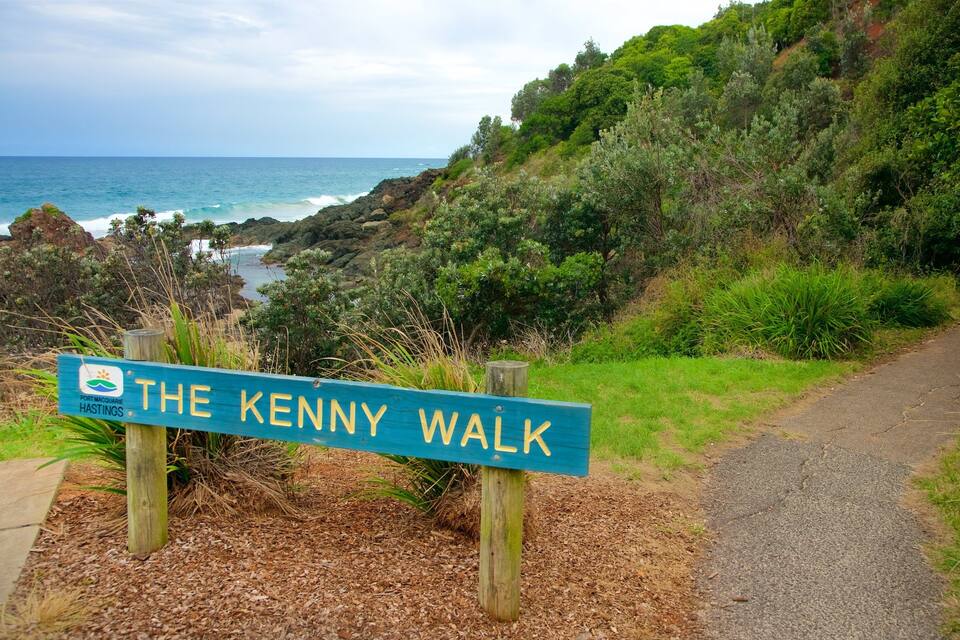 A sign for The Kenny Walk with a coastal view in the background.