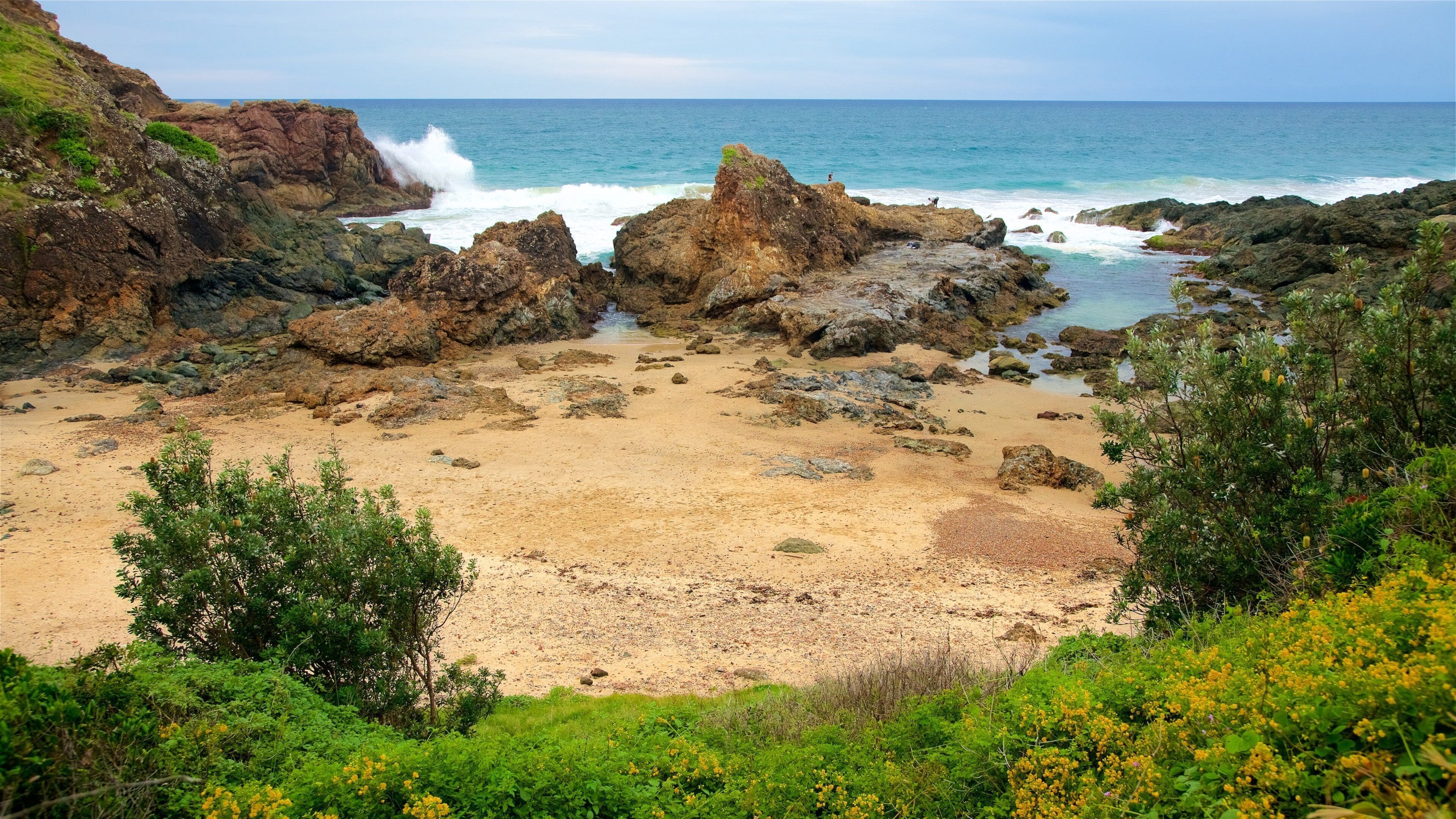 North Coast showing a beach, waves and a bay or harbour