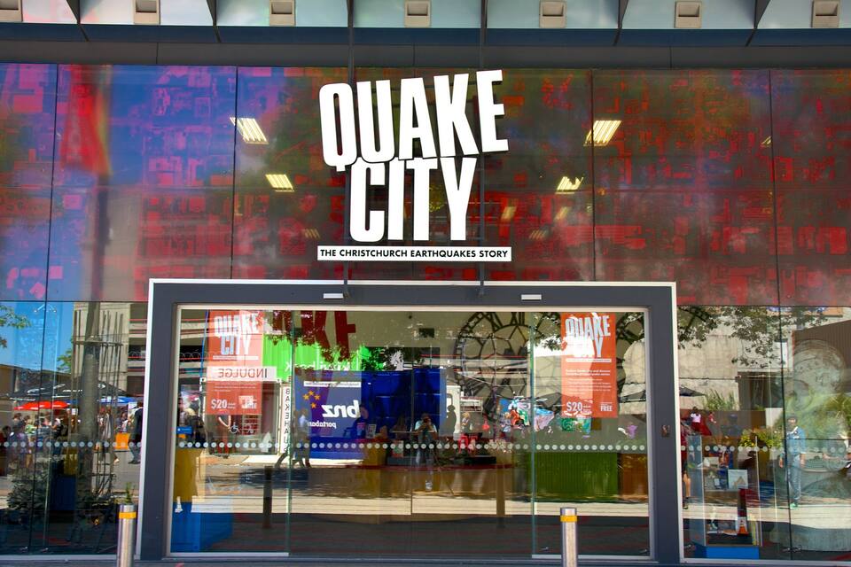 Fachada de loja com uma grande placa que diz “QUAKE CITY” e um subtítulo “A HISTÓRIA DOS TERREMOTOS DE CHRISTCHURCH”.