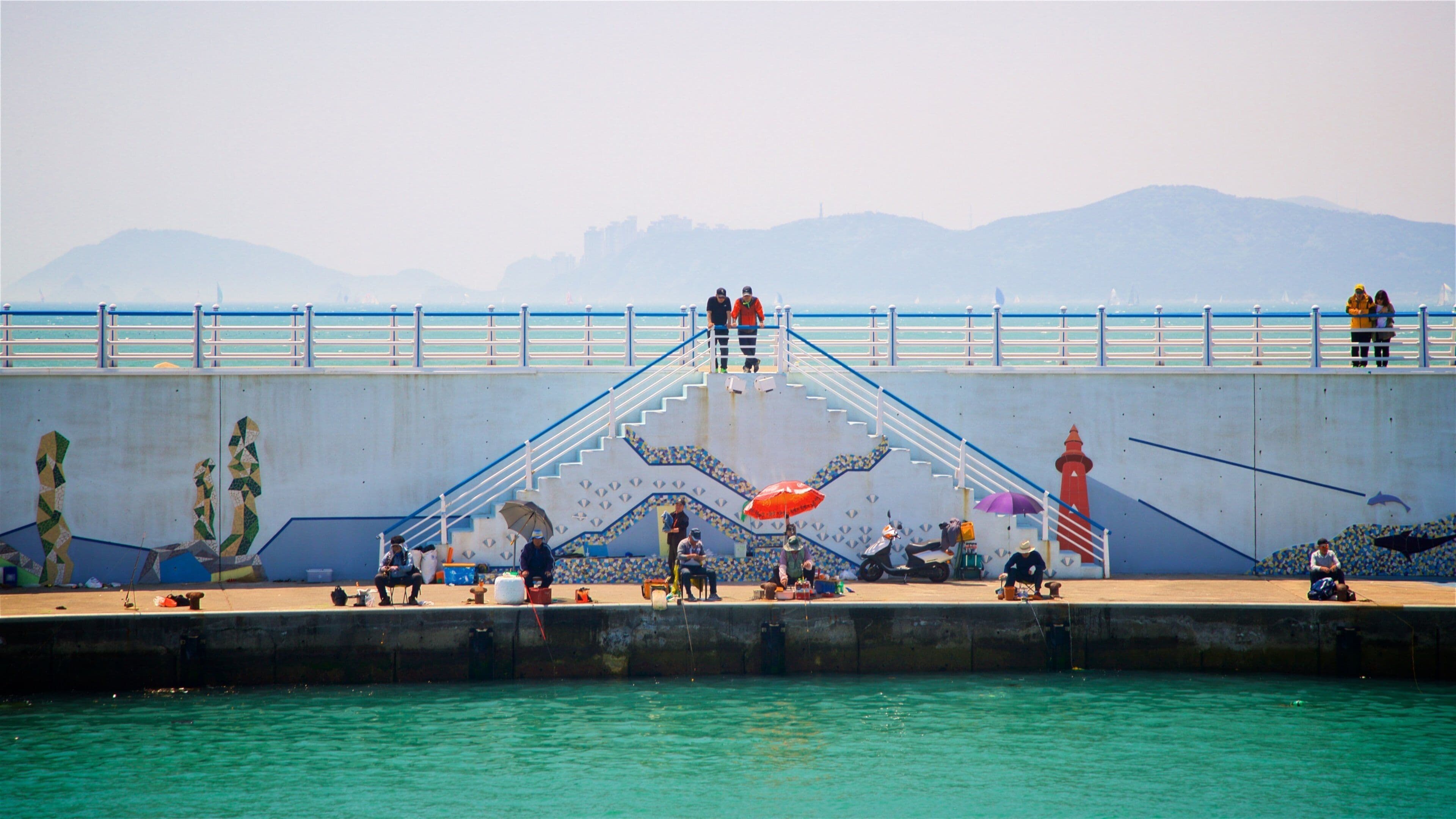Busan which includes outdoor art and general coastal views as well as a small group of people