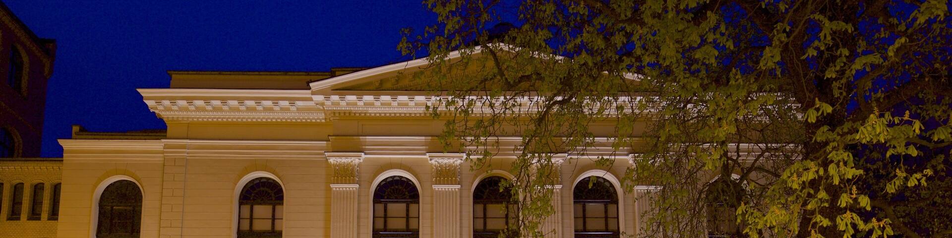A classical building with large arched windows and a central entrance.