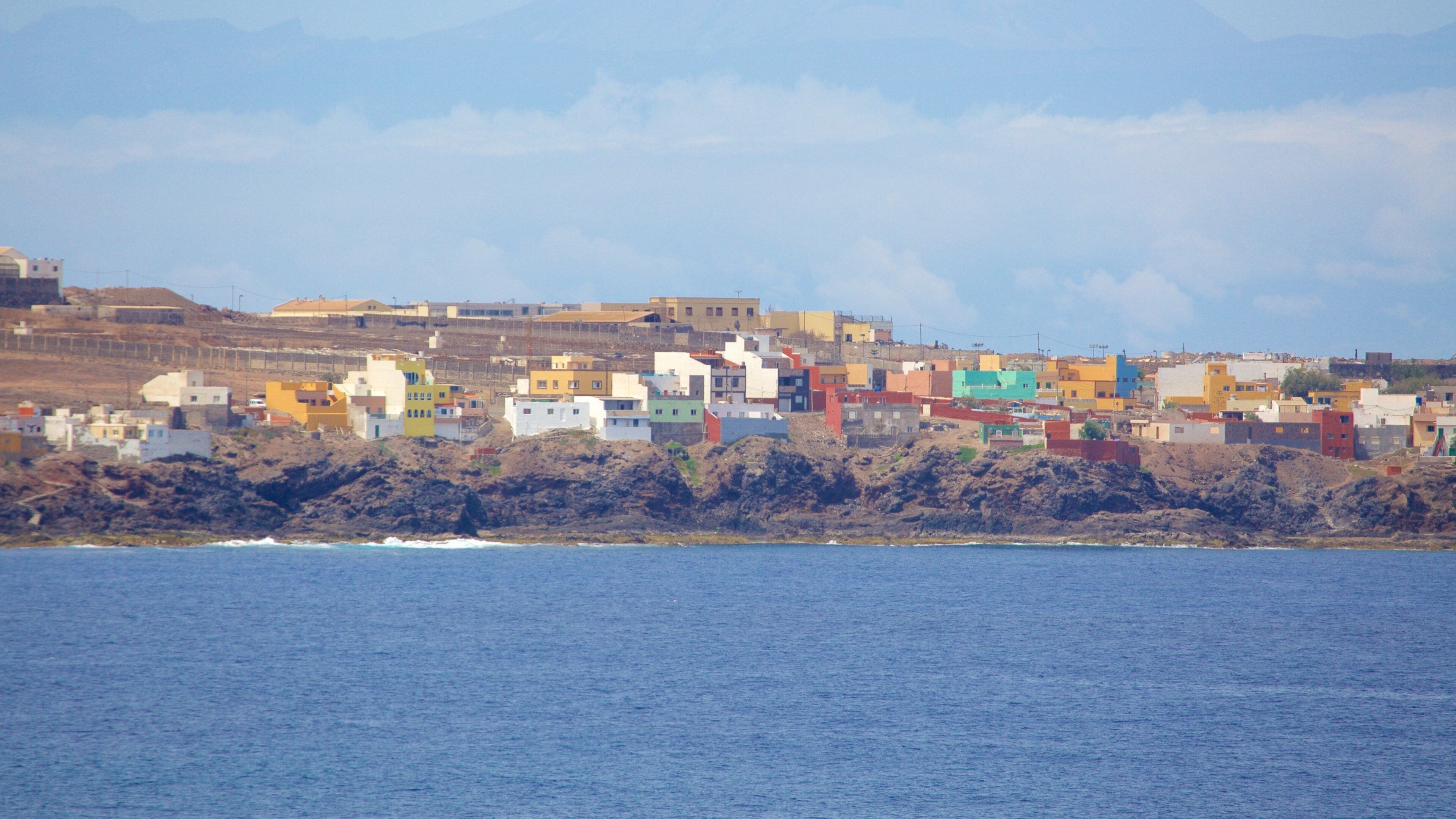 Caleta de Arriba which includes rocky coastline, general coastal views and a coastal town