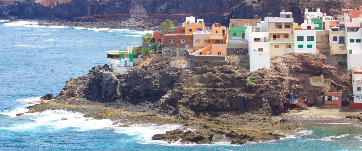 A coastal village with colorful buildings perched on rocky cliffs overlooking the sea.