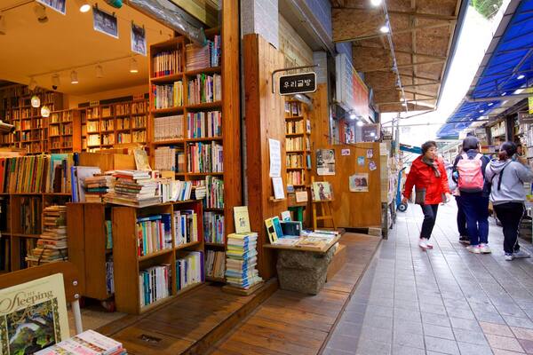 Une librairie avec des étagères en bois remplies de livres.