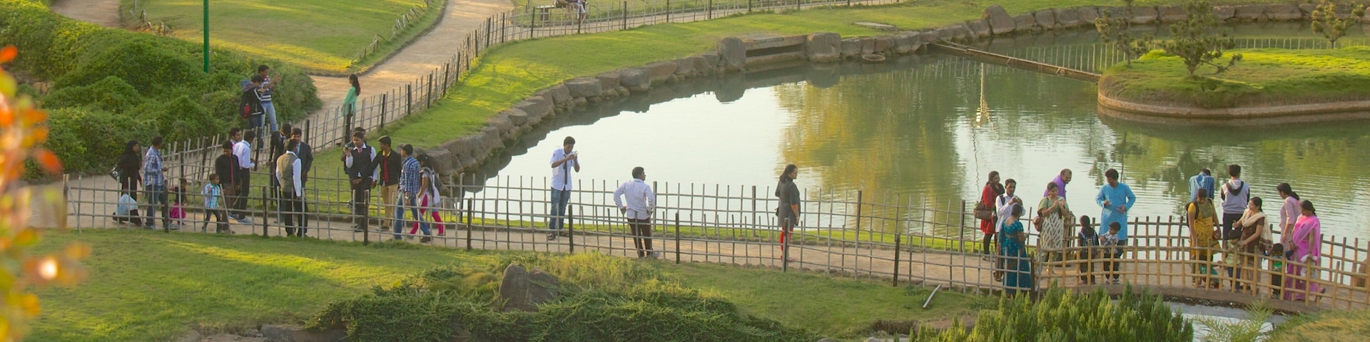 Pune featuring a lake or waterhole and a garden as well as a large group of people