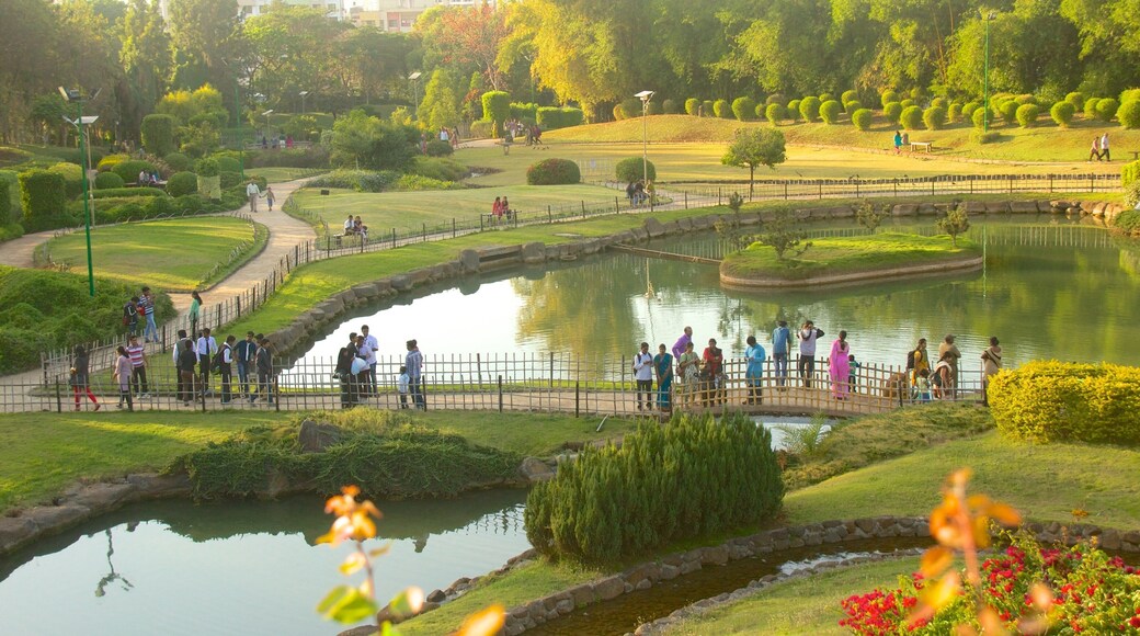 Pune showing a pond and a garden as well as a large group of people