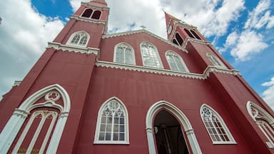 A red church with white trim and multiple arched windows.