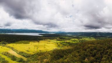 A mountainous landscape with a lake and a green valley.