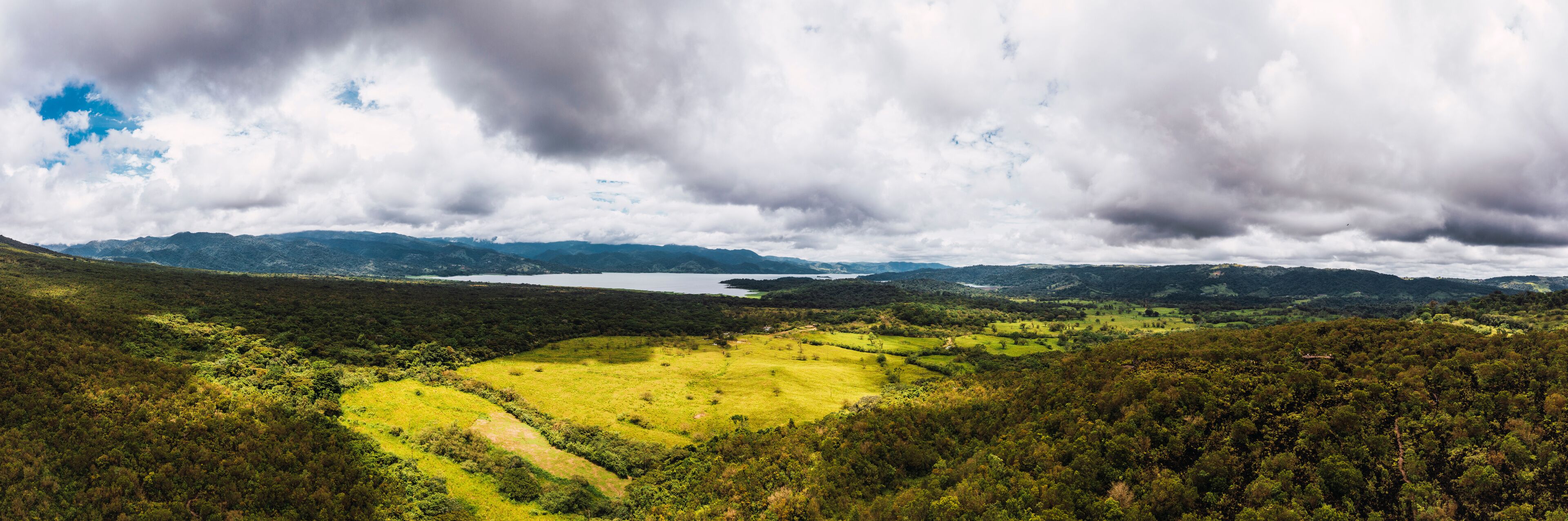 A mountainous landscape with a lake and a green valley.