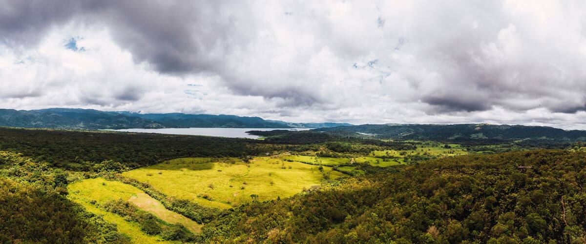 A mountainous landscape with a lake and a green valley.