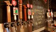 A beer tap area with various taps and labels, including 'Brown Ale' and 'Red IPA'.