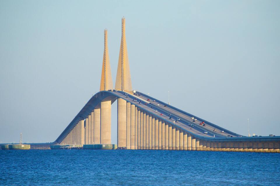 A large bridge with two tall towers and a curved roadway over water.