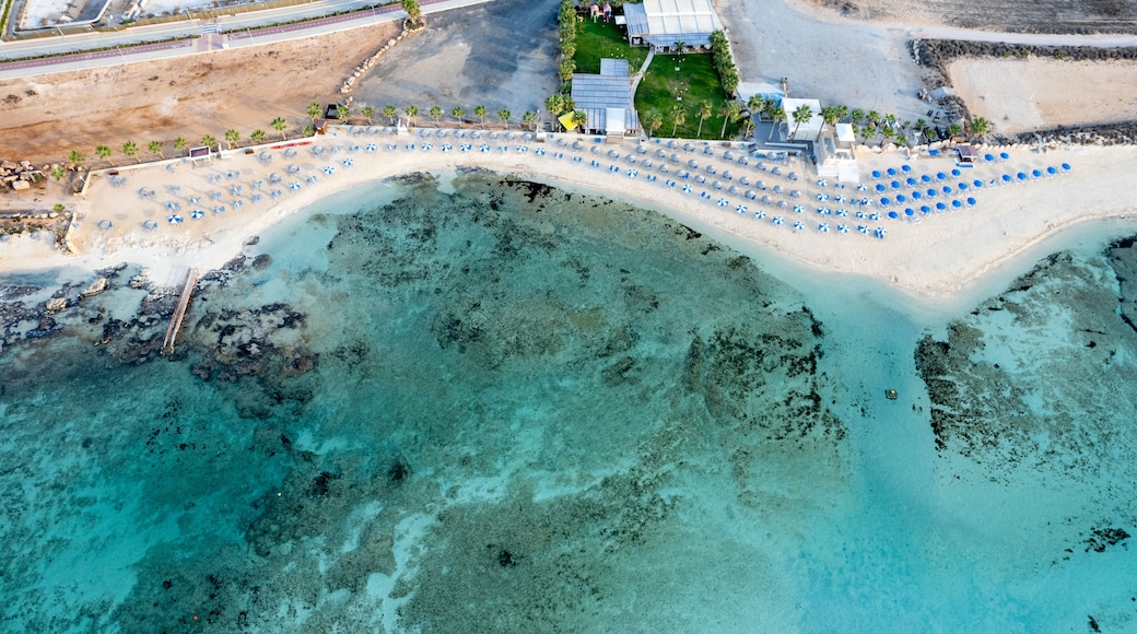 Drone aerial top view of a holiday resort and coastline with turquoise sea water.