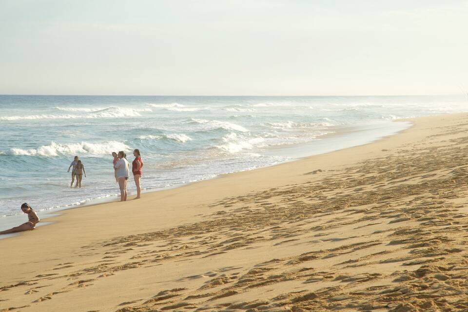 A sandy beach with waves crashing onto the shore.