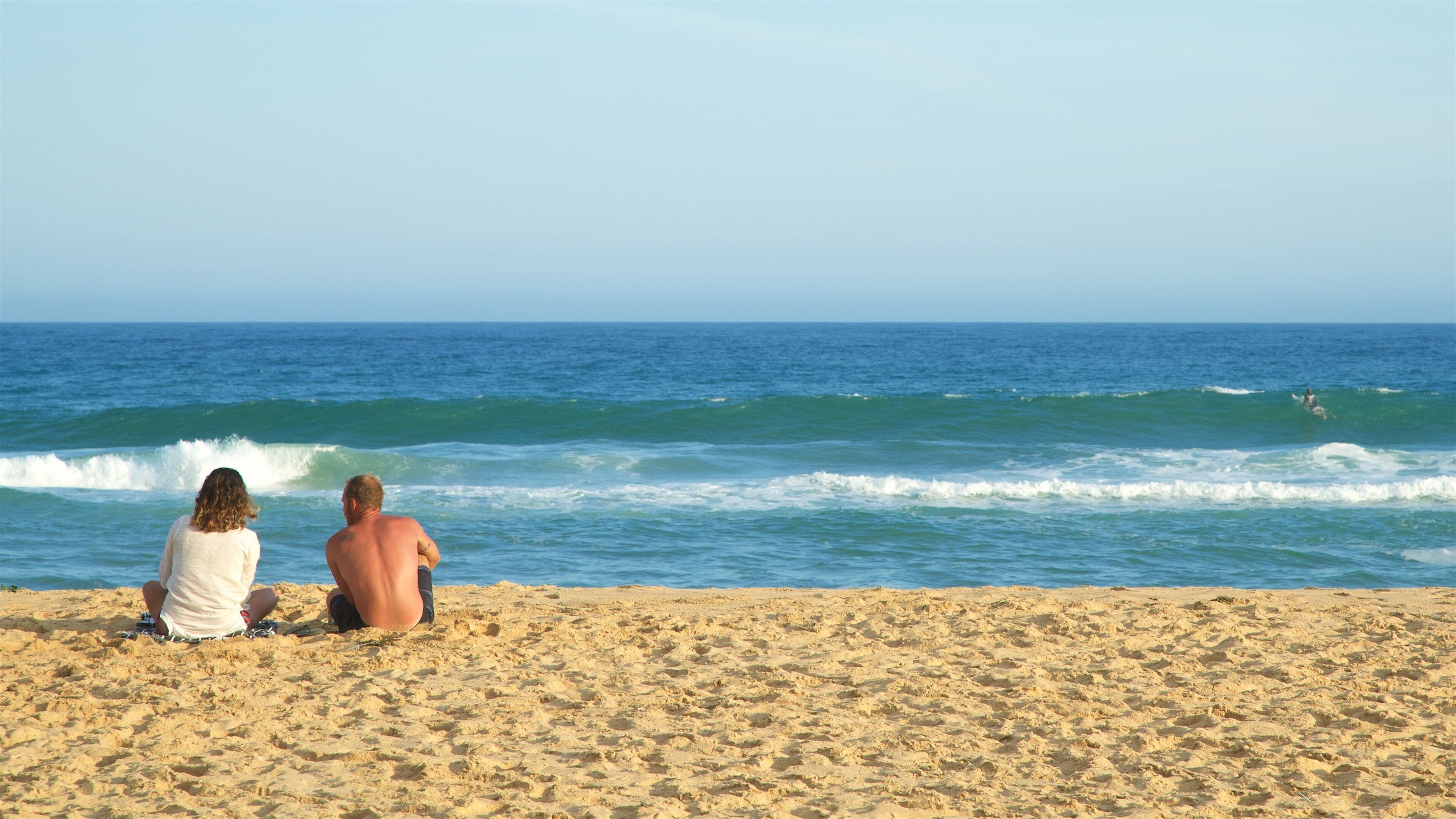Lakes Entrance que incluye una bahía o puerto, una playa y olas