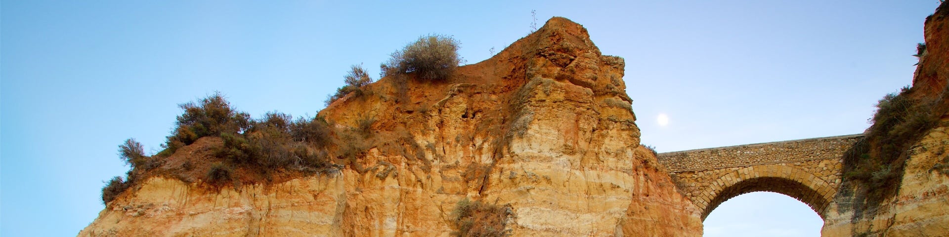 Lagos featuring rocky coastline, a bridge and a sandy beach