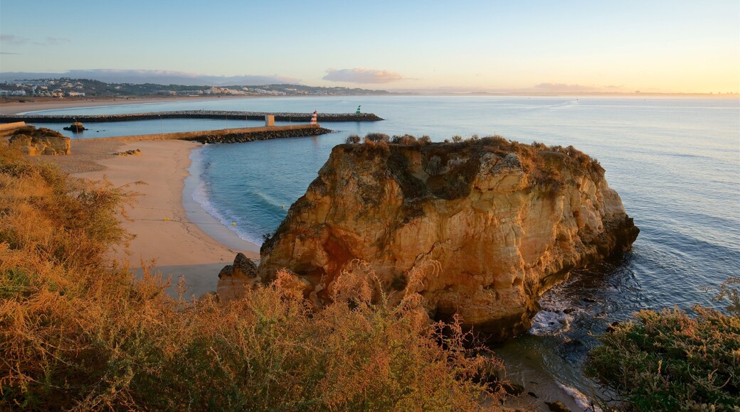 Lagos inclusief een zandstrand, een zonsondergang en rotsachtige kustlijn