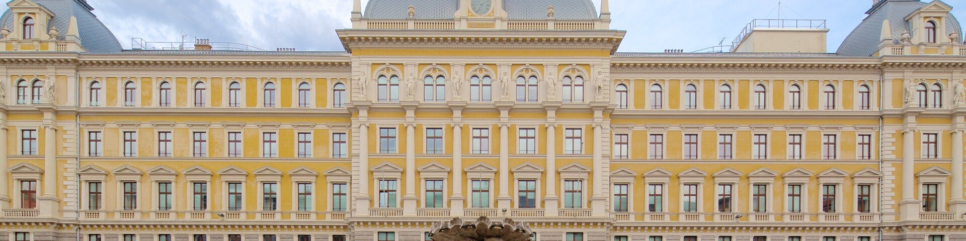 Trieste caracterizando uma fonte, um edifício administrativo e uma praça ou plaza
