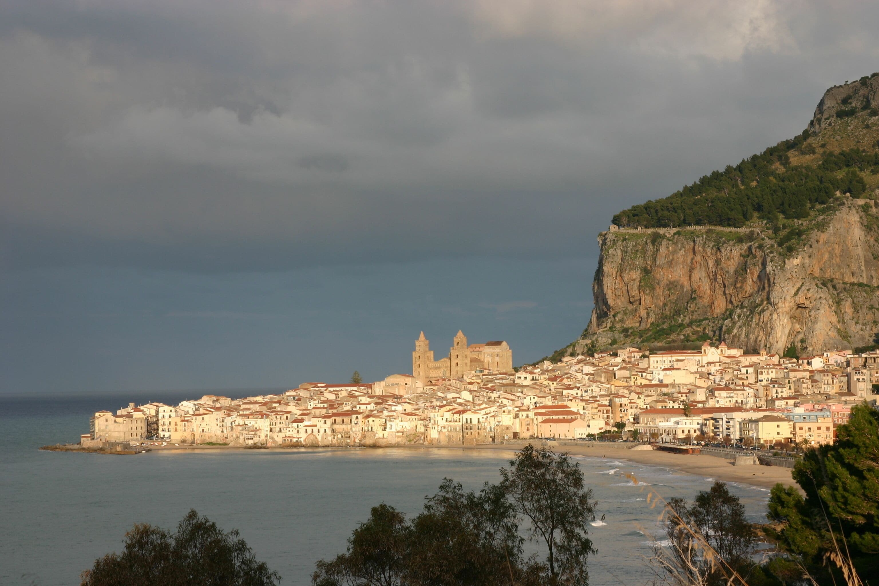 A coastal town with a prominent church and a cliff overlooking the sea.