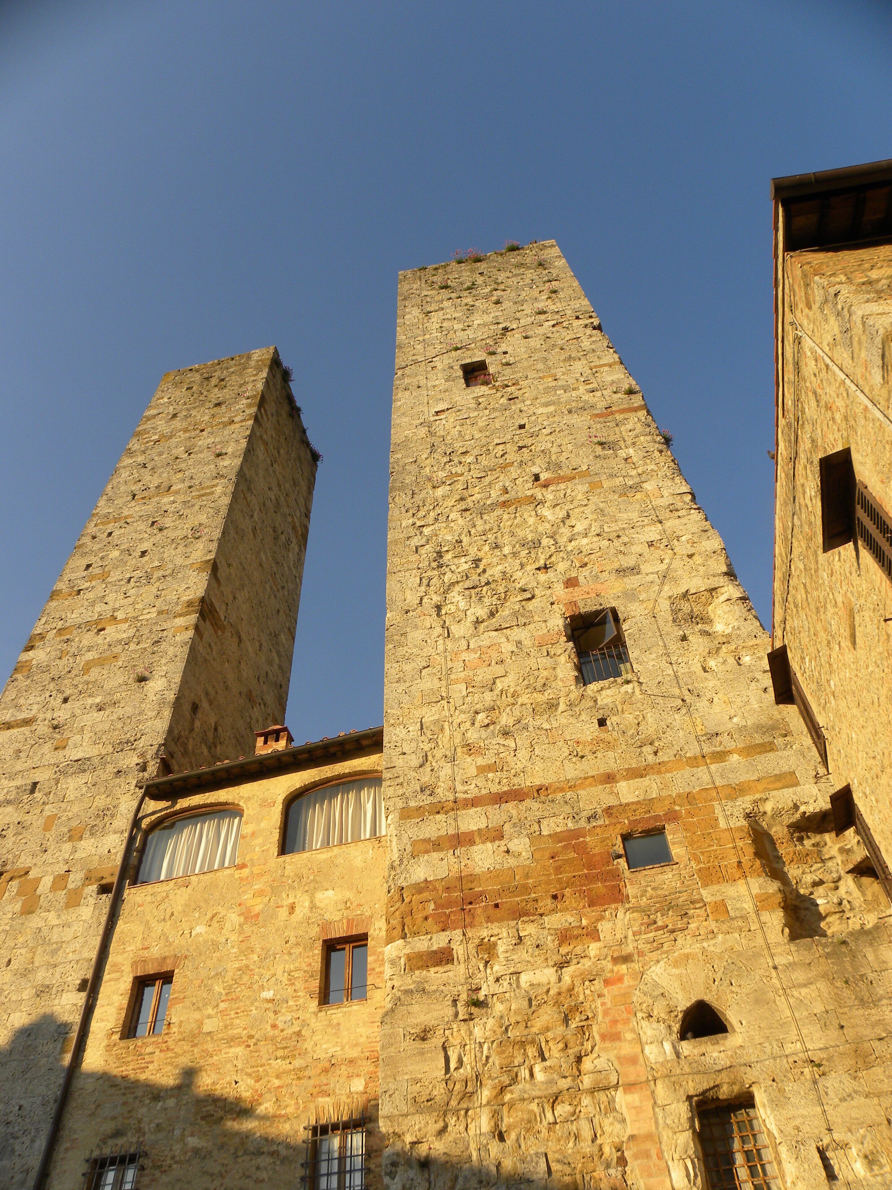 Two tall stone towers with arched windows and a clear blue sky.