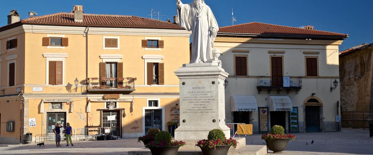 Norcia qui includes statue ou sculpture et fleurs