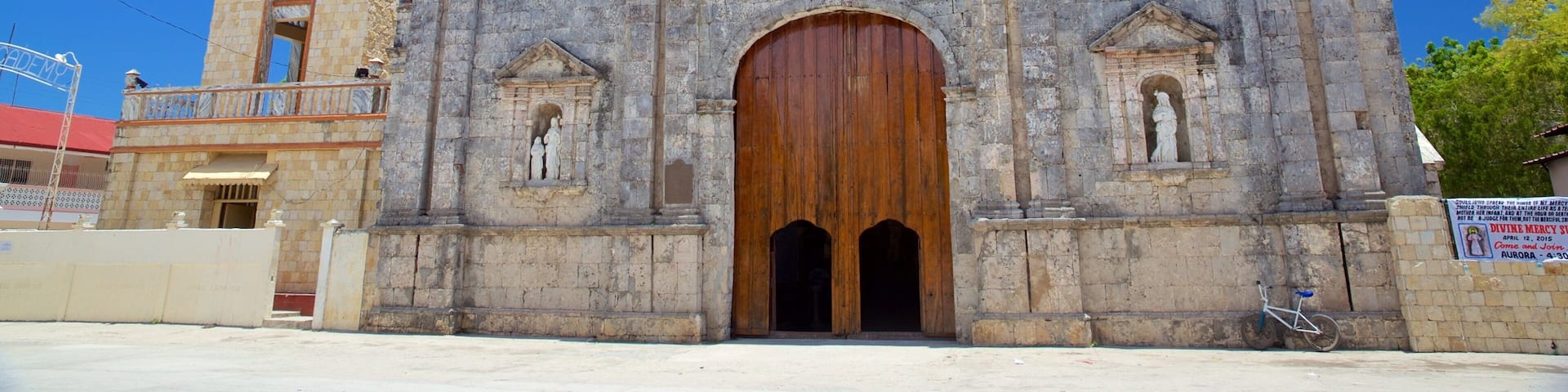 A historic church with a large wooden door, bell tower, and crosses.