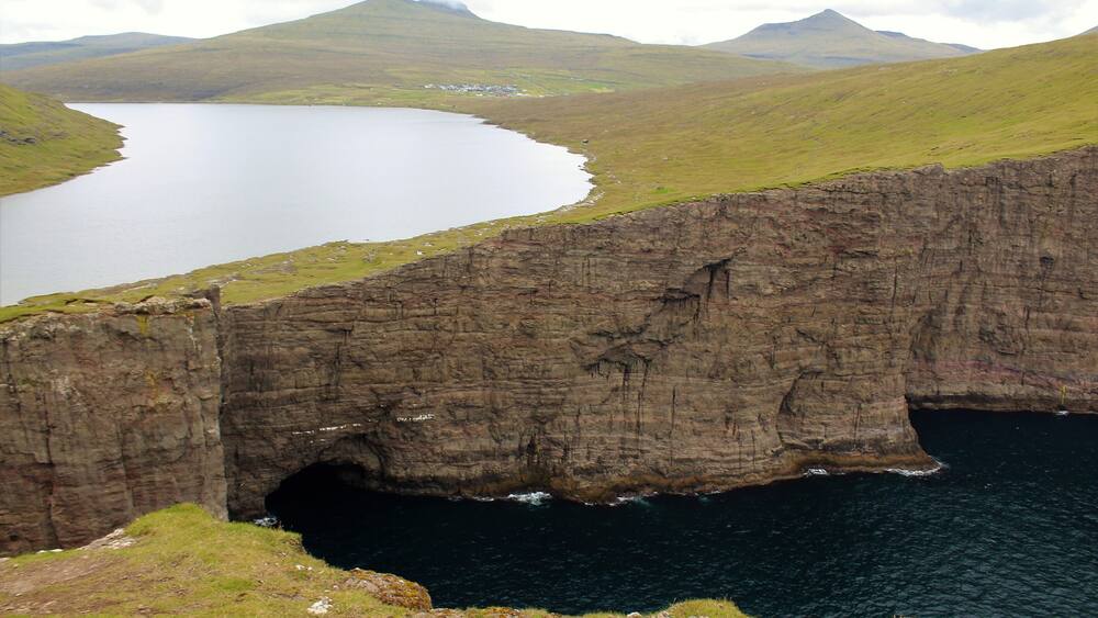 One of the most surreal places I've visited - Sørvágsvatn in the Faroe Islands! Had a great time there on August 26th. The more iconic view of this lake actually is much more panoramic, showing views further to the left. But I was so in awe of what I witnessed that I simply forgot to take a panoramic photo of that! Oh well, as the saying goes: there is always next time, right? :) I still did manage to get some cool shots and am glad for that. Especially since the wind could be a little strong at times! Especially near this viewpoint here. I was perilously close to that edge. And anyway, this is a must-visit for anyone going to the Faroes! It's a few KM hike but so well worth it. And the visible trail makes it quite easy to get there. Plus, you are likely to walk with other tourists anyway ;).