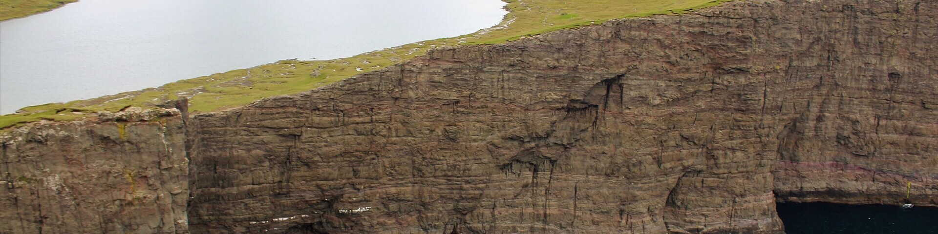 One of the most surreal places I've visited - Sørvágsvatn in the Faroe Islands! Had a great time there on August 26th. The more iconic view of this lake actually is much more panoramic, showing views further to the left. But I was so in awe of what I witnessed that I simply forgot to take a panoramic photo of that! Oh well, as the saying goes: there is always next time, right? :) I still did manage to get some cool shots and am glad for that. Especially since the wind could be a little strong at times! Especially near this viewpoint here. I was perilously close to that edge. And anyway, this is a must-visit for anyone going to the Faroes! It's a few KM hike but so well worth it. And the visible trail makes it quite easy to get there. Plus, you are likely to walk with other tourists anyway ;).