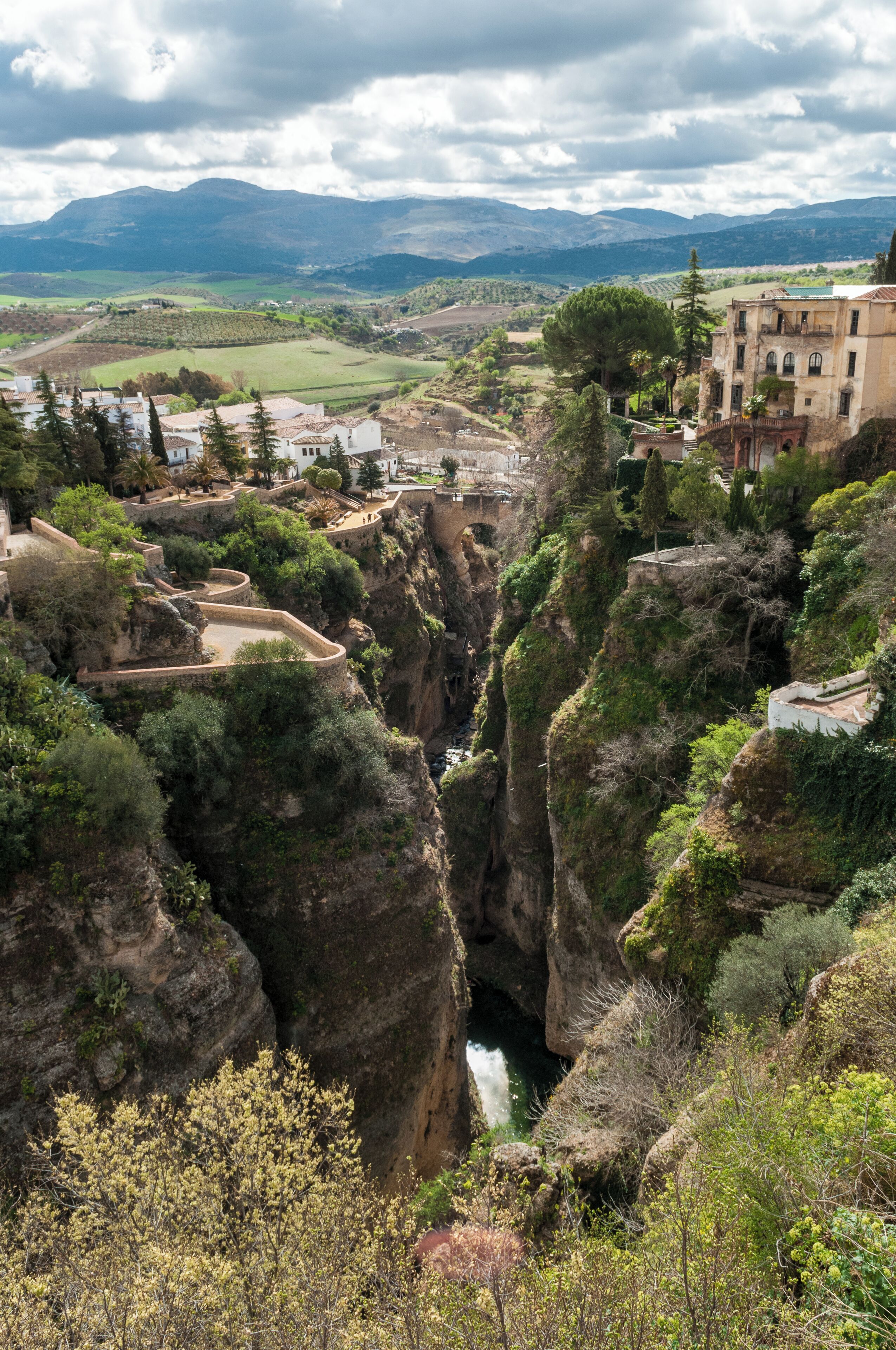 Un cañón con un río que lo atraviesa, rodeado de acantilados rocosos y vegetación.