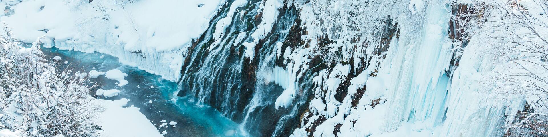 Shirahige Waterfall with Snow in winter, Biei river flow into Blue Pond. landmark and popular for attractions in Hokkaido, Japan. Travel and Vacation concept