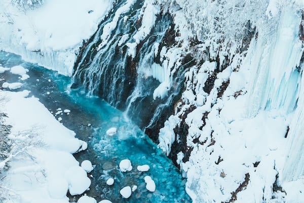Shirahige Waterfall with Snow in winter, Biei river flow into Blue Pond. landmark and popular for attractions in Hokkaido, Japan. Travel and Vacation concept