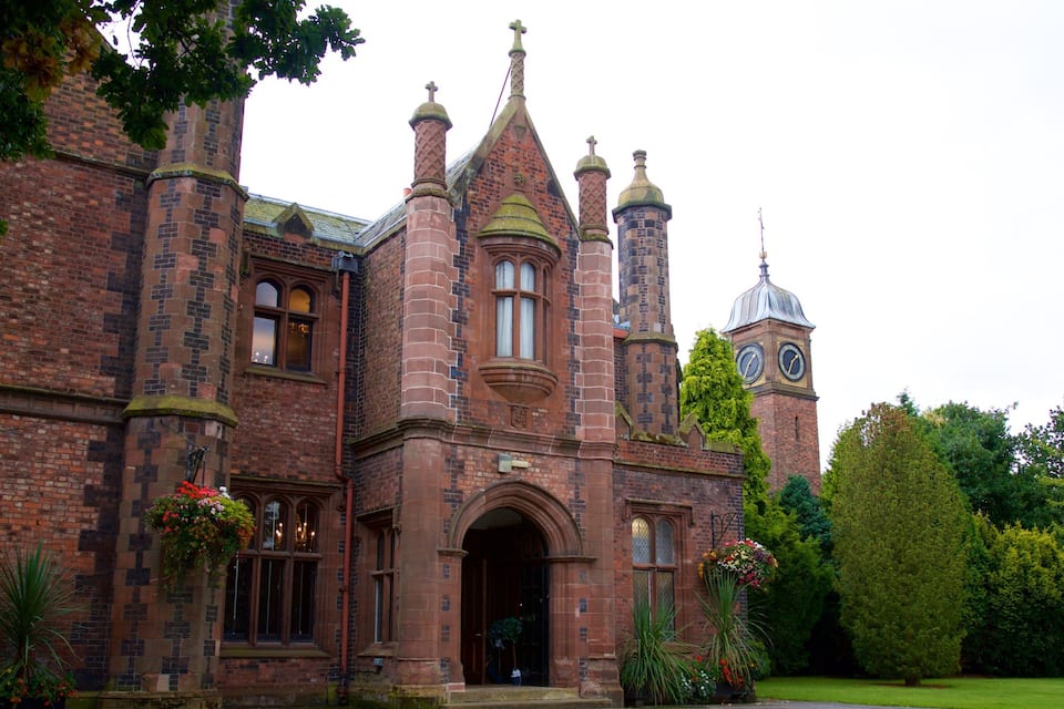 A historic building with a clock tower, arched windows, and brickwork.