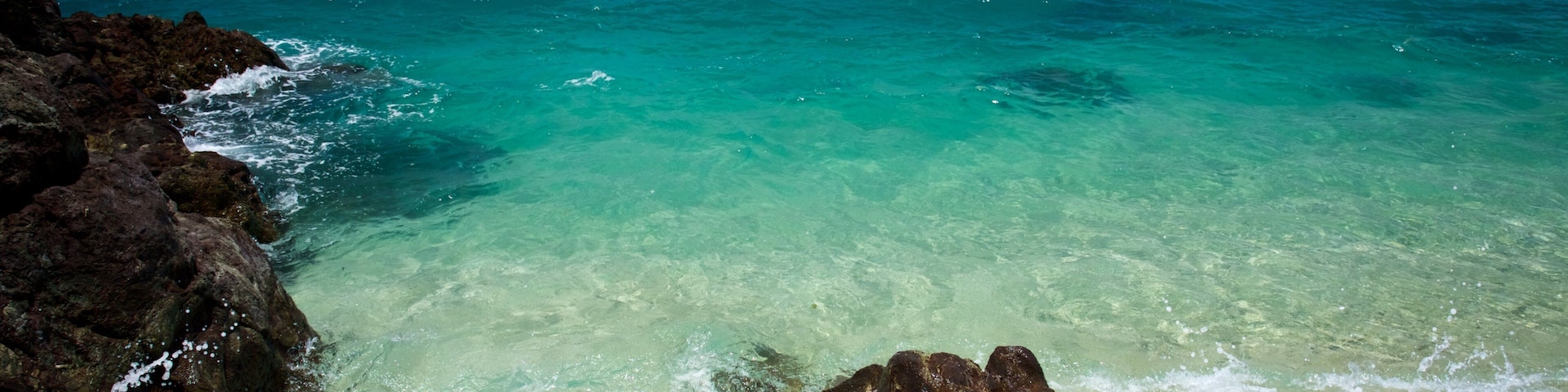 Daydream Island showing rocky coastline, a pebble beach and landscape views
