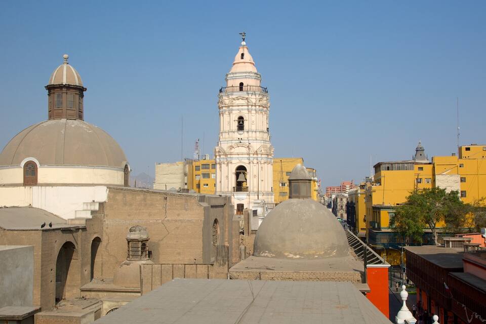 A historic building with a bell tower and dome, surrounded by urban buildings.