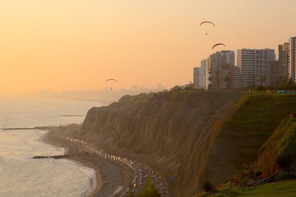 Lima joka esittää yleiset rantanäkymät, auringonlasku ja kaupunki