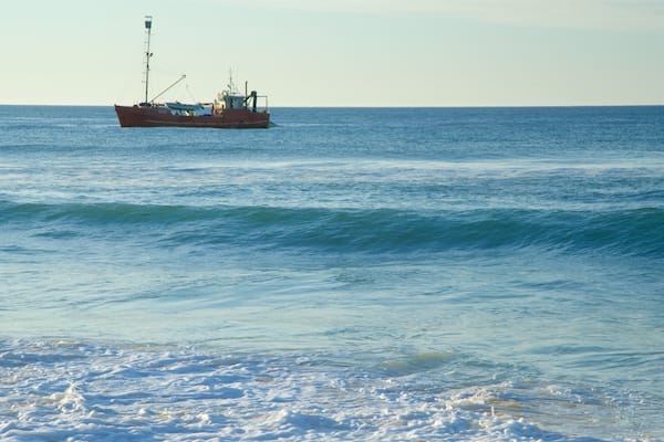 Main Beach which includes general coastal views, a sunset and boating