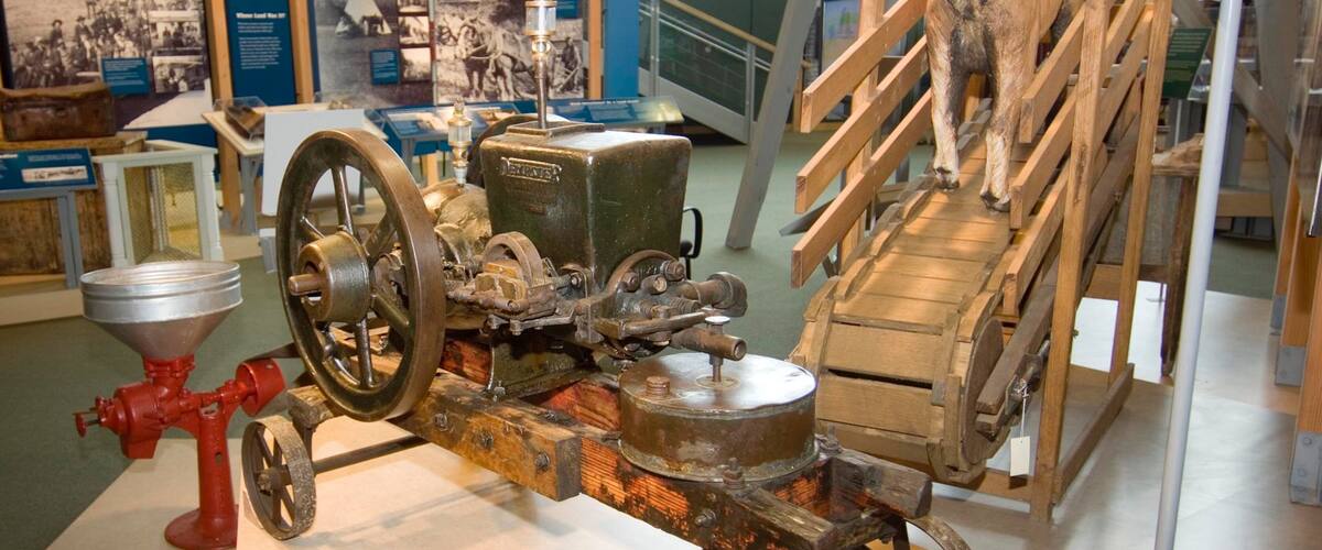 An old-fashioned mechanical device with wheels and a wooden structure.