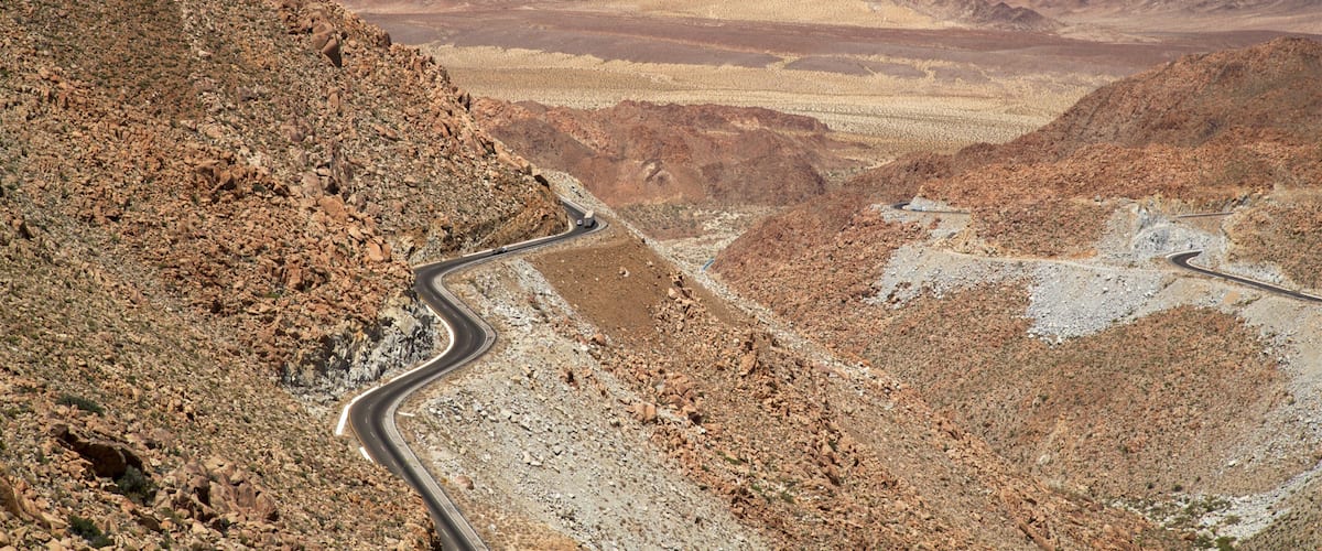 A winding mountain road in a rocky desert landscape.