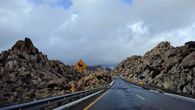 Una carretera bordeada por rocas grandes bajo un cielo nublado.