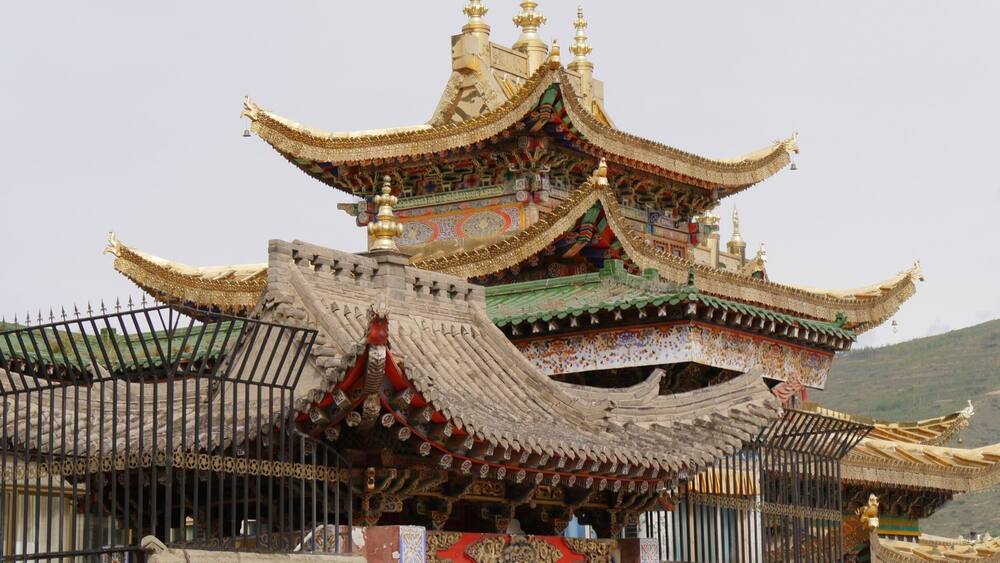 A traditional multi-tiered temple with ornate golden roofs and intricate decorations.