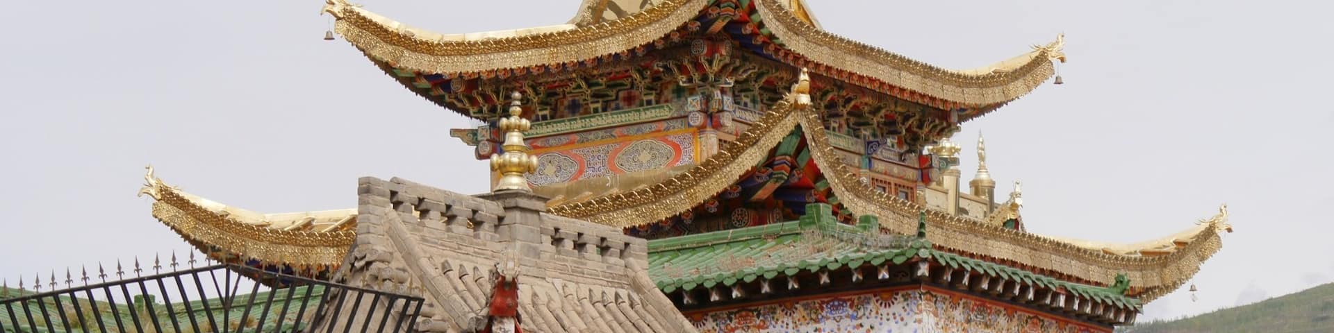 Gilded and stone rooftops at the Longwu Monastery, Rebkong, China.