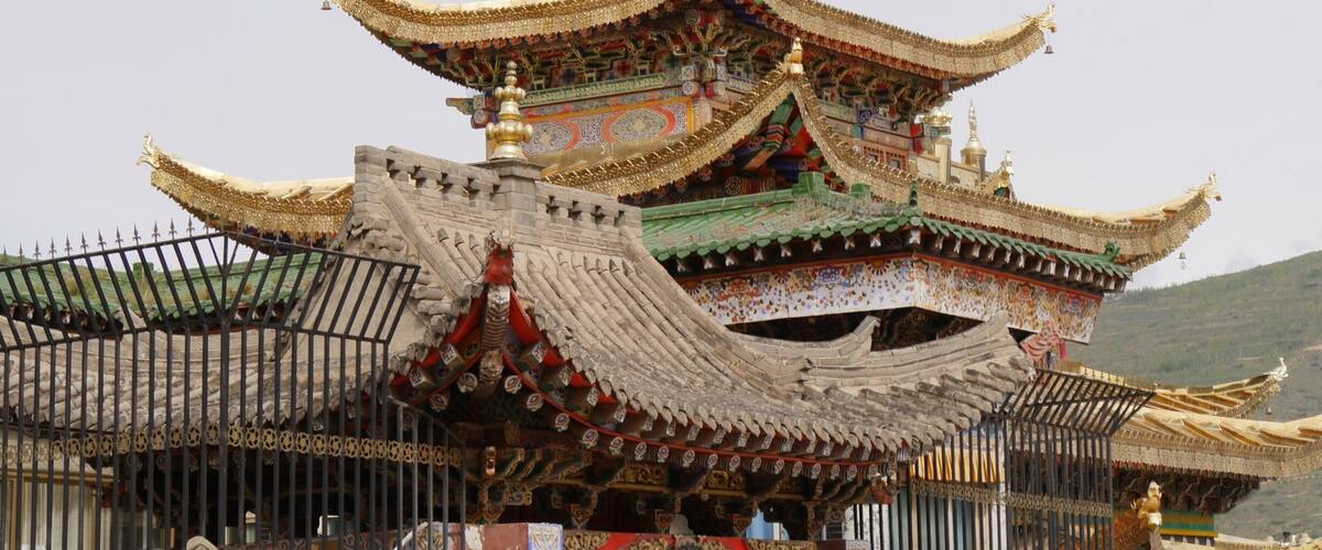 A traditional multi-tiered temple with ornate golden roofs and intricate decorations.