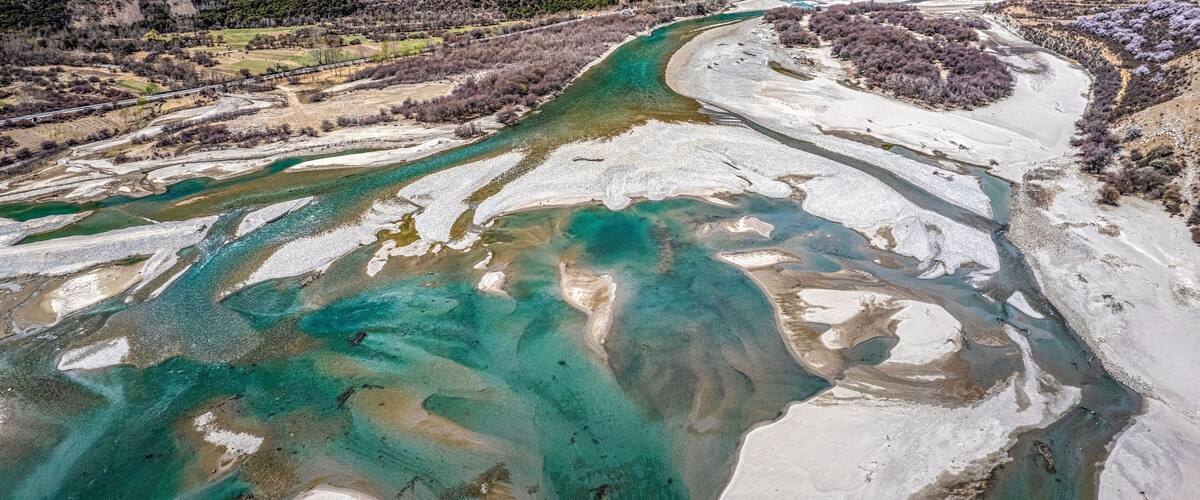 A river with clear turquoise water flowing through a mountainous landscape.
