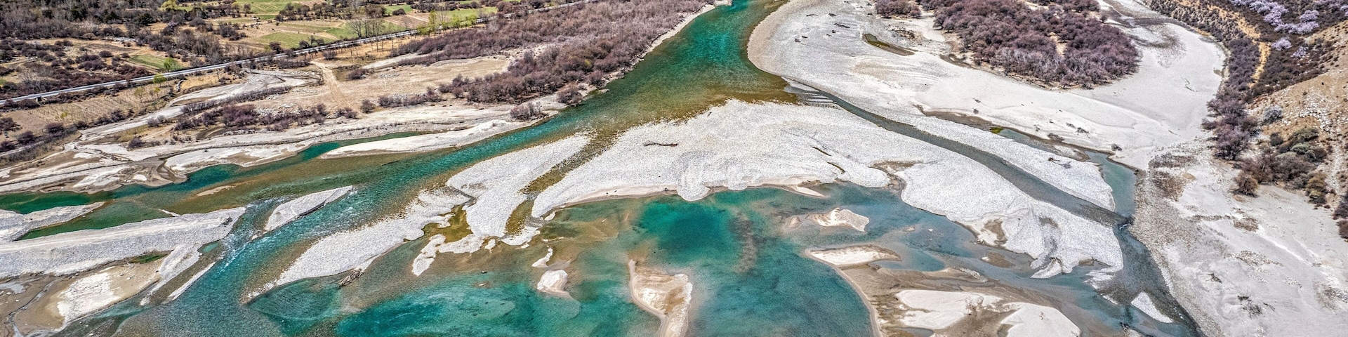 A river with clear turquoise water flowing through a mountainous landscape.